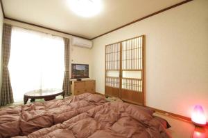 羽村市JR羽村駅徒歩14分凝った内装でゆったり2DKb203的一间带床、窗户和桌子的卧室