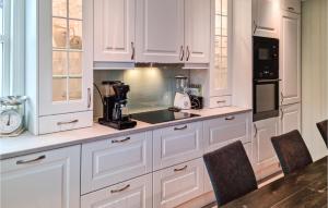 Una cocina con gabinetes blancos y encimera. en Awesome Home In Lillesand With Wifi, en Lillesand