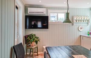 comedor con mesa de madera y TV en Awesome Home In Lillesand With Wifi, en Lillesand