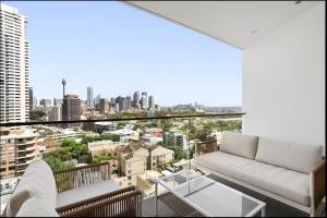 a living room with a couch and a view of a city at Stylish Double Storey Apt plus Harbour Bridge Views! in Sydney