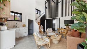 a kitchen and living room with a table and chairs at Catalyst Retreat - Stylish, Pets, Accessible, Sauna in Coffs Harbour