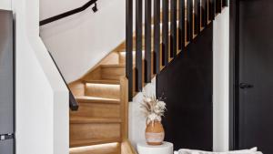 a staircase in a house with a vase at Catalyst Retreat - Stylish, Pets, Accessible, Sauna in Coffs Harbour