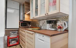 Una cocina con gabinetes blancos y una encimera de madera. en Lovely Apartment In Allinge With Wifi, en Allinge