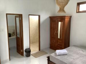 Schlafzimmer mit einem Bett, einem Schrank und einem Spiegel in der Unterkunft Villa iris Homestay in Uluwatu + 25 Fotos