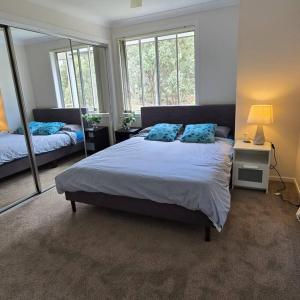 a bedroom with a large bed and a mirror at Cosy 5 x bedroom Kellyvil Ridge in Kellyville