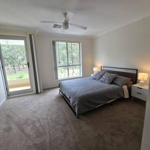 a bedroom with a bed with two lamps and a window at Cosy 5 x bedroom Kellyvil Ridge in Kellyville