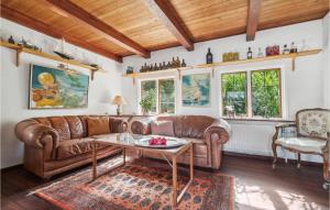 a living room with a leather couch and a table at Nice Home In Nexø With Wifi in Neksø