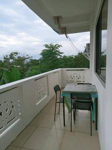a balcony with a table and chairs and a window at Cozy 2-Bedroom Apartment in Boracay