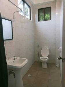a white bathroom with a toilet and a sink at Cozy 2-Bedroom Apartment in Boracay +31 photos