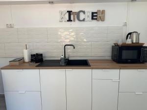 a kitchen counter with a sink and a microwave at L Univers ORA in Pamandzi