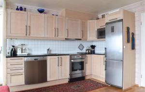 a kitchen with wooden cabinets and stainless steel appliances at Fjellstua C3, Leil 202 in Sjusjøen