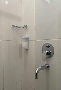 eine Badezimmerkabine mit Dusche und Wasserhahn in der Unterkunft Binumar Guest House in Pekalongan
