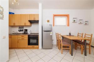 a kitchen with a table and a refrigerator at Apartman Julija in Povile