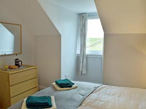 a bedroom with a bed with a window and towels at Brick Cottage 2-Uk13675 in Palnure +3 photos