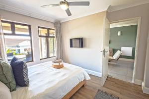 una camera da letto con un letto, una tv e una finestra di Modern self-catering apartment in a secure estate a Plettenberg Bay Altre 25 foto