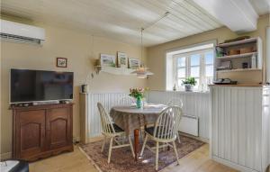a dining room with a table and chairs and a tv at Holiday Home Skårupøre Strandvej in Skårupøre