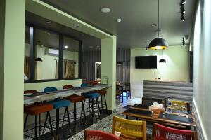 a restaurant with tables and chairs and a tv at The Infigo in Beherāpāt