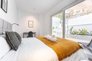 ein Schlafzimmer mit einem großen Bett und einem großen Fenster in der Unterkunft Apartamento en el Palo in Málaga