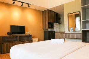 ブカシにあるSimply Look Studio Room Gateway Park LRT City Jatibening Apartment By Travelioの大きなベッドとテレビのある寝室