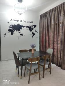 a table and chairs with a map of the world on a wall at 55 Homestay Bakri Muar Lovely House 12 pax in Kampong Parit Ulu