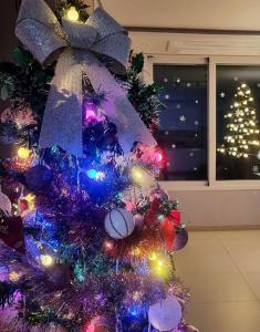 einen violetten Weihnachtsbaum mit Lichtern an einem Fenster in der Unterkunft Pink room 4 bedroom in Seoul