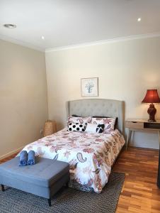 a bedroom with a bed with pillows and a table at Coastal Comforts in Aspendale