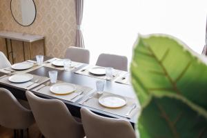 a table with chairs and plates and a plant at ReStayしっぽタウンヴィラ今宮駅 in Osaka