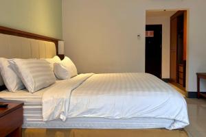 Ένα ή περισσότερα κρεβάτια σε δωμάτιο στο Thong's Inn Hotel Kualanamu