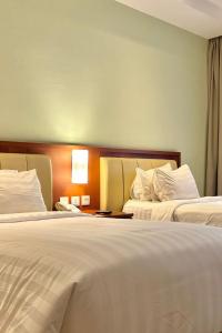Ένα ή περισσότερα κρεβάτια σε δωμάτιο στο Thong's Inn Hotel Kualanamu