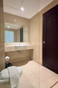 un bagno con lavandino, water e specchio di Thong's Inn Hotel Kualanamu a Medan Altre 37 foto