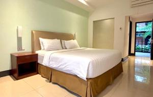 Ένα ή περισσότερα κρεβάτια σε δωμάτιο στο Thong's Inn Hotel Kualanamu