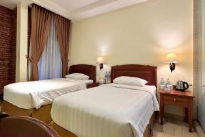Ένα ή περισσότερα κρεβάτια σε δωμάτιο στο Thong's Inn Hotel Kualanamu