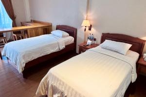 Ένα ή περισσότερα κρεβάτια σε δωμάτιο στο Thong's Inn Hotel Kualanamu