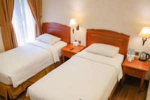 Ένα ή περισσότερα κρεβάτια σε δωμάτιο στο Thong's Inn Hotel Kualanamu