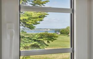 a window view of a lake from a house at Three-Bedroom Holiday Home In Sydals in Kongshoved