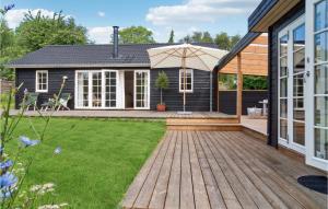 un patio trasero con una terraza de madera y una casa en Amazing Home In Gilleleje With Wifi, en Gilleleje