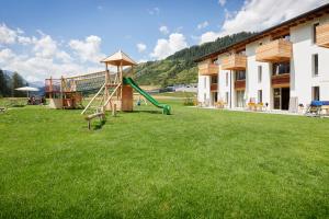 a playground in front of a building with a slide at Reka-Ferienanlage Scuol in Scuol
