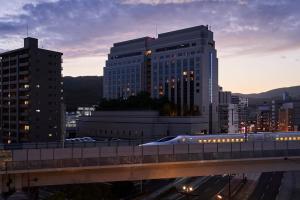 a train on a bridge in a city with buildings at THE GLOBAL VIEW Nagasaki in Nagasaki +36 photos