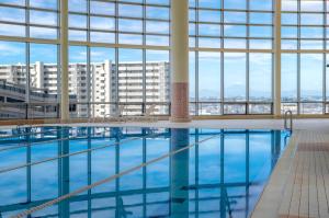 a swimming pool in a large building with windows at The Mark Grand Hotel in Saitama