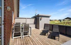 a patio with a table and chairs on a deck at Nice Home In Hvide Sande With Sauna in Bjerregård