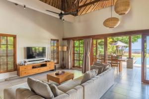 Una sala de estar con un sofá y un televisor. en Villa Emerald, en Banjar