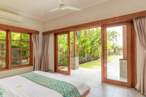 Un dormitorio con una cama y puertas corredizas de vidrio. en Villa Emerald, en Banjar 28 fotos más