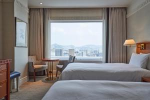 a hotel room with two beds and a large window at THE GLOBAL VIEW Nagasaki in Nagasaki