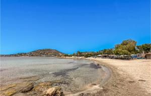 a sandy beach with a mountain in the background at 3 Bedroom Cozy Home In Koropi in Áyios Nikólaos +21 photos