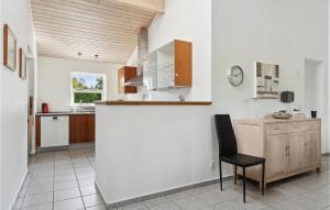 a kitchen with a counter and a chair in a room at Beautiful Home In Væggerløse With Sauna in Bøtø By