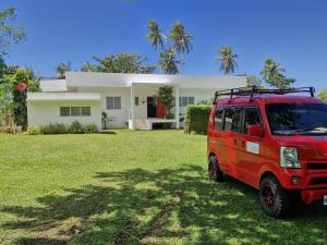 a red van parked in front of a house at ArtVilla Camiguin - Luxus Homestay mit Infinity Pool und Sunset View in Mambajao