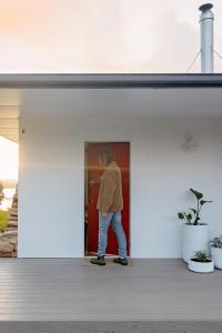 una persona parada en una puerta de una casa en The Red Door Strahan, en Strahan