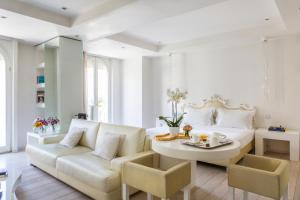 a living room with a white couch and a table at Boscolo Nice Hotel & Spa in Nice