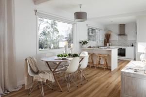 a kitchen and dining room with a table and chairs at The Red Door Strahan in Strahan