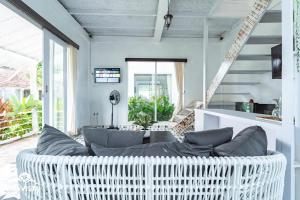 a living room with a white wicker couch at D'Pendem Cottage's by Bukit Vista in Uluwatu